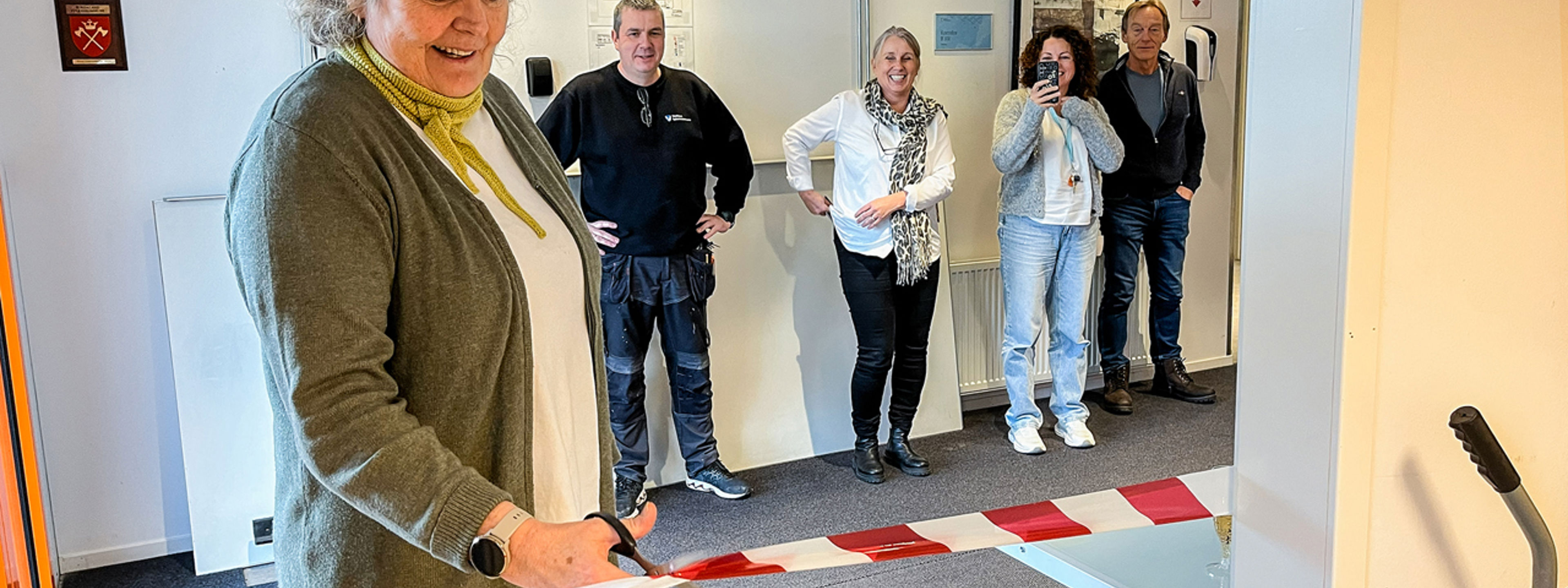 Dame som klypper snor i samband med opninga av nytt varemottak