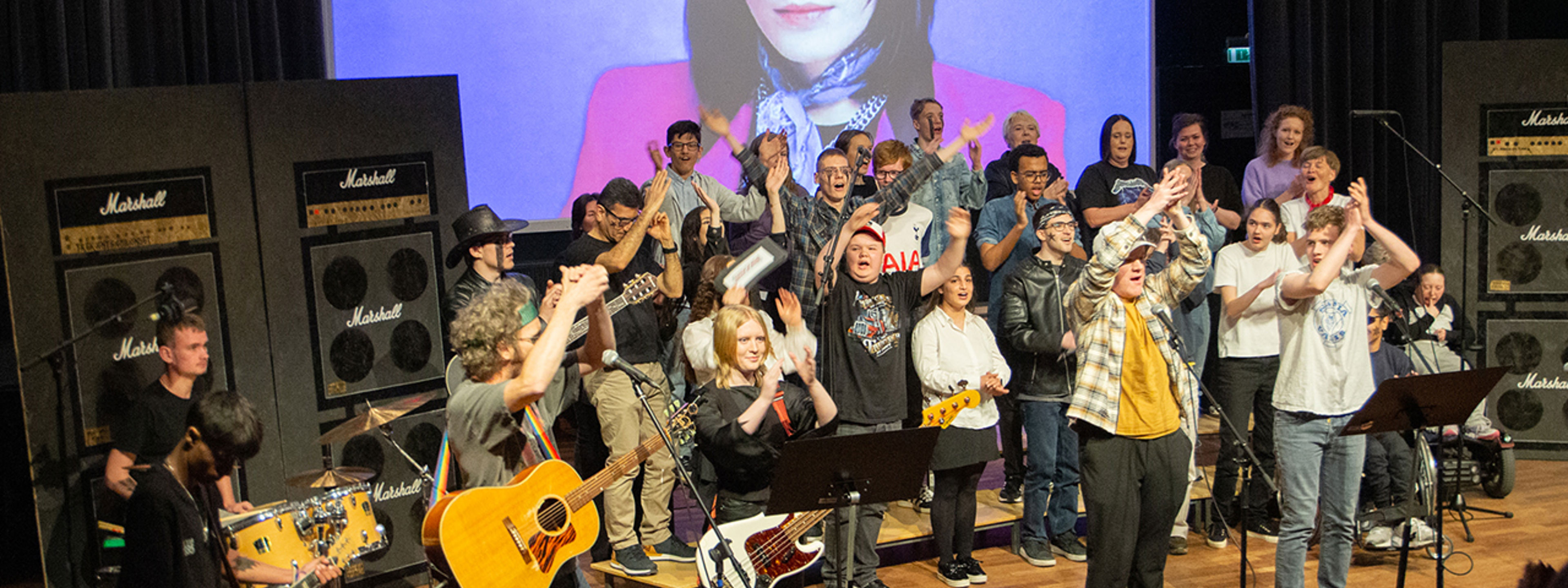 Elevar på Tilrettelagt opplæring som opptrer på scene med førestillinga "School of Rock"