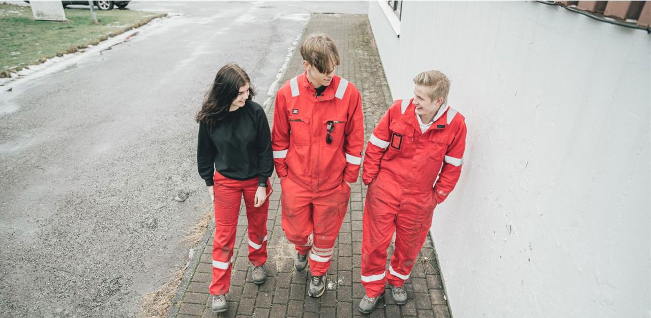Tre lærlingar i raud kjeledress
