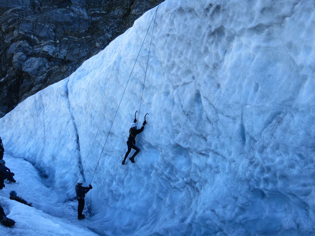  Elev som klatrar opp ein fjellvegg med snø og is